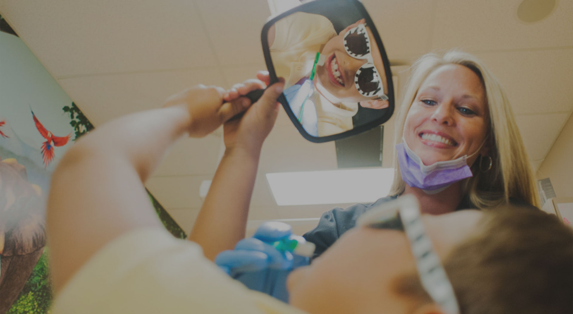 Child with mirror at Holdbrook Pediatric Dental